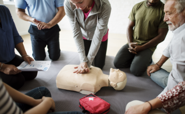 A group of people practicing CPR on a training dummy